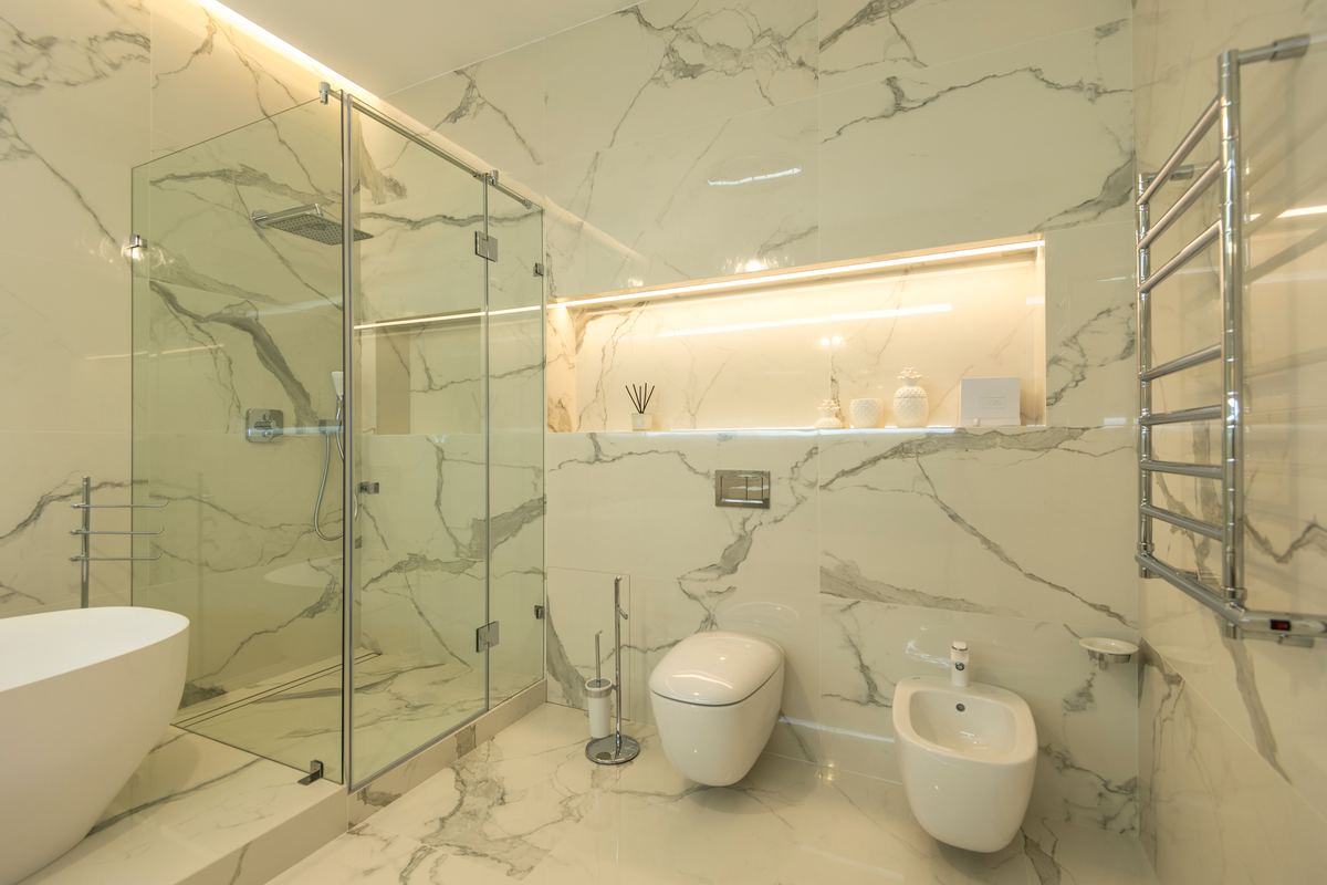 Baño de diseño con mampara de ducha de rincón y mármol, ejemplo de instalación a medida